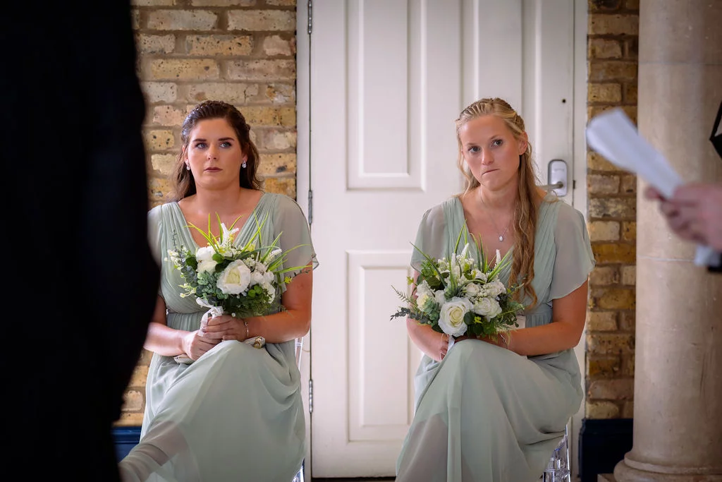 Two bridesmaids sitting next to each other.