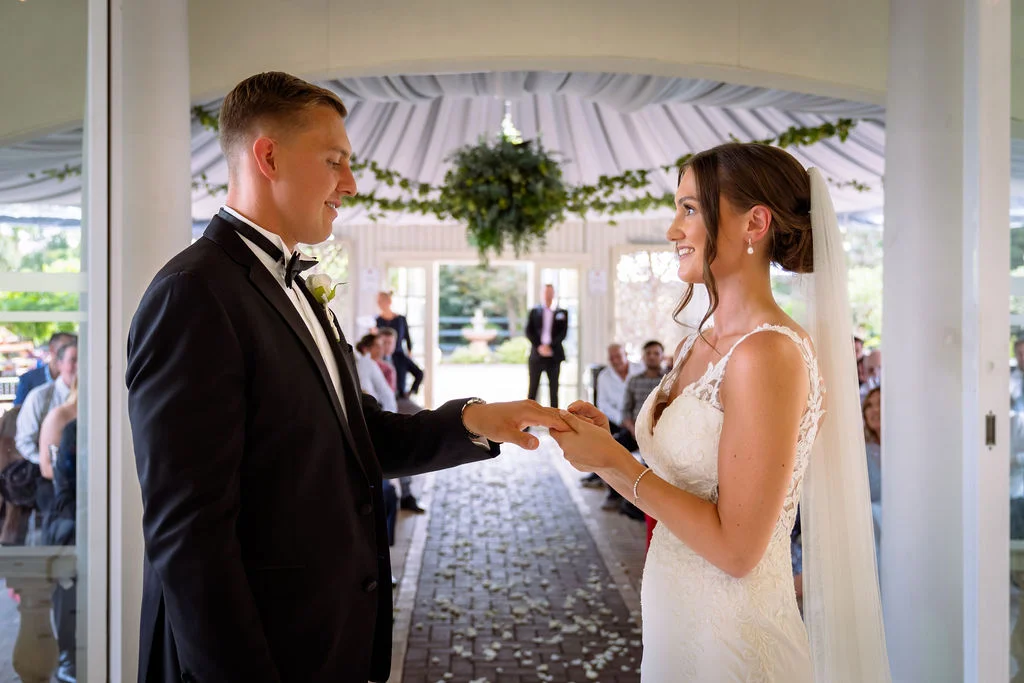 A bride and groom exchange rings at their wedding ceremony.