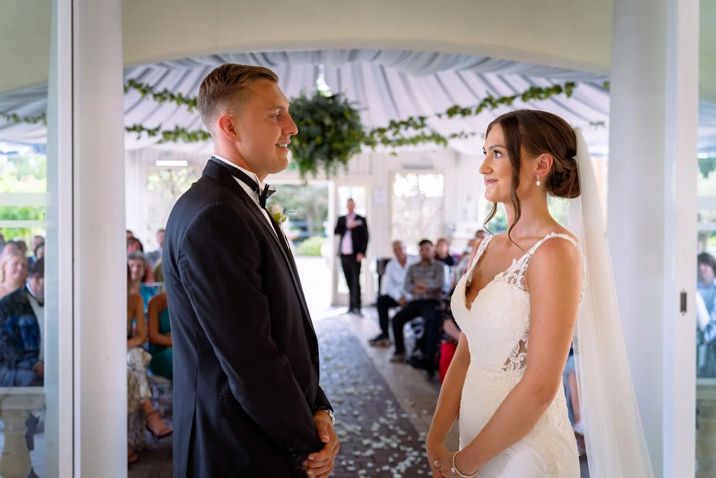 A bride and groom look at each other during their wedding ceremony.