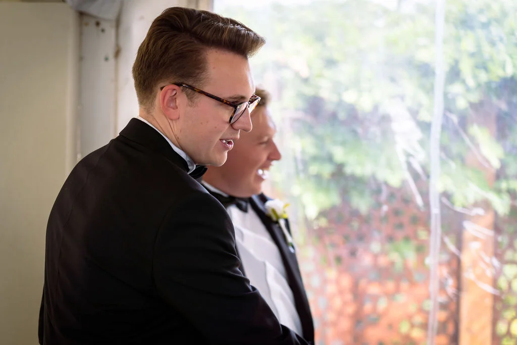 Two men in tuxedos standing next to each other.