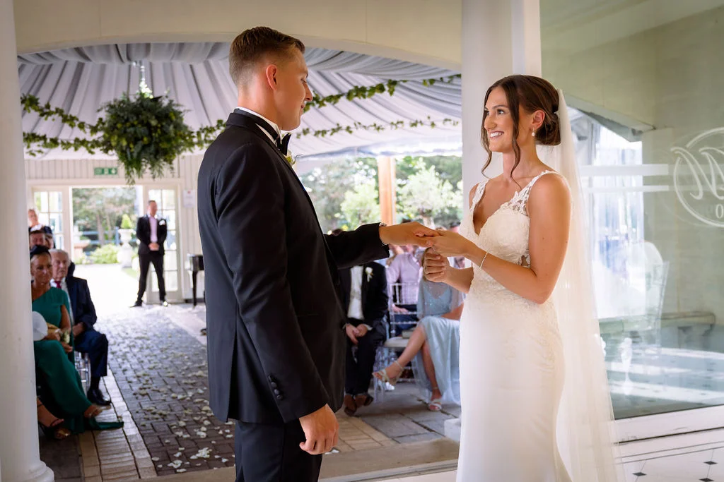A bride and groom exchanging their wedding rings at a wedding ceremony.