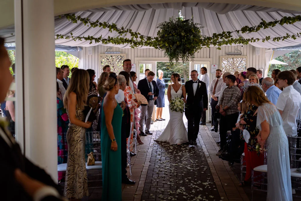 A bride and groom walking down the aisle.