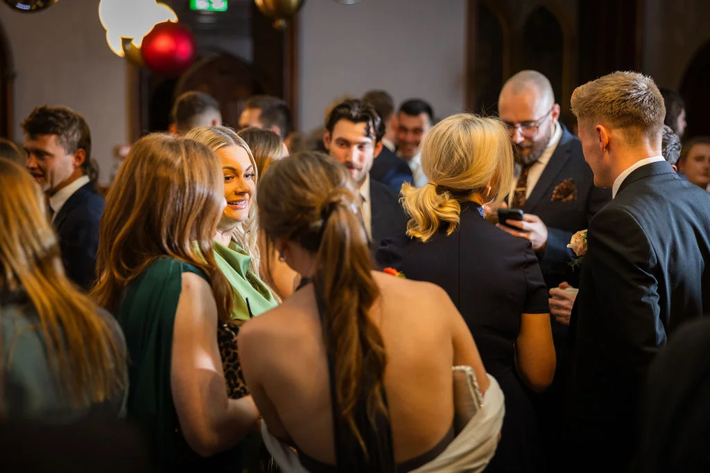 A lively candid shot of wedding guests mingling and chatting together during the evening drinks reception.