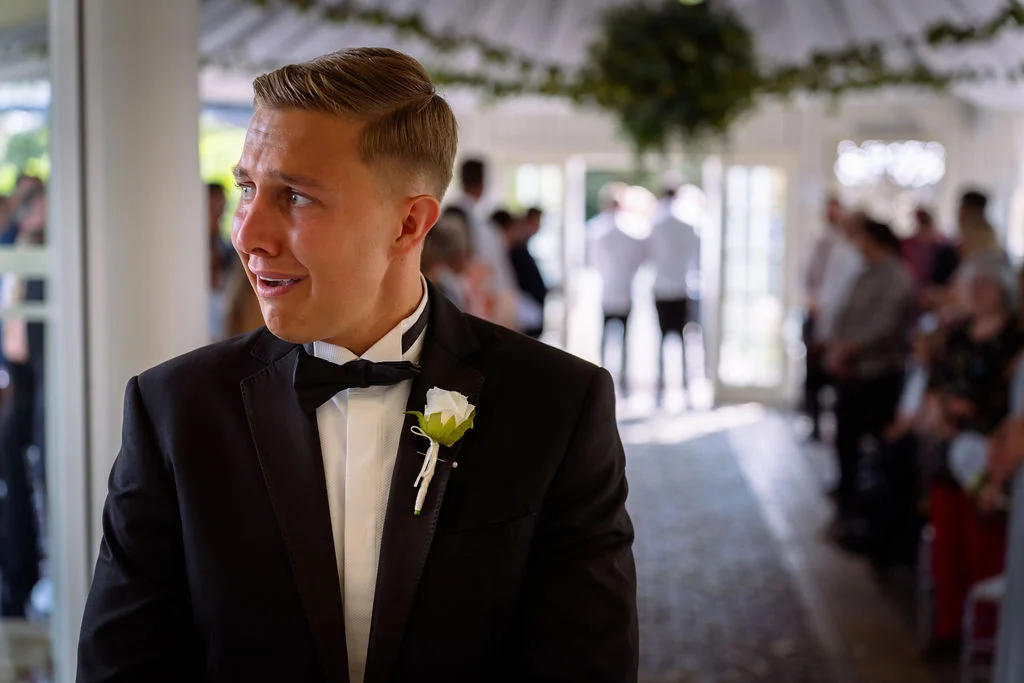 A man in a tuxedo standing in a room.