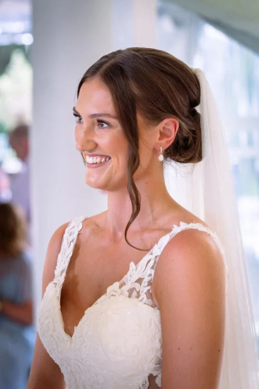 A bride smiles as she walks down the aisle.