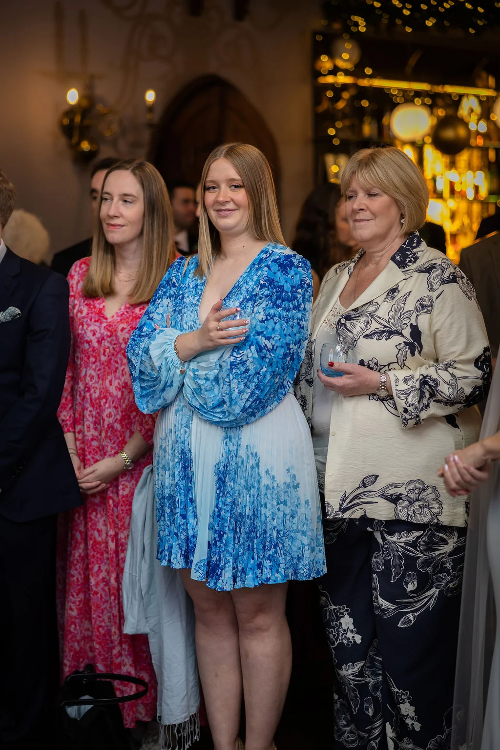 A candid indoor photograph of wedding guests smiling and mingling during the drinks reception.