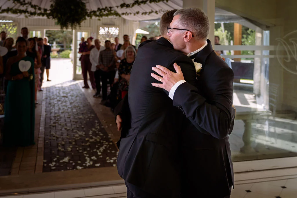 A bride and groom hugging at the end of their wedding ceremony.