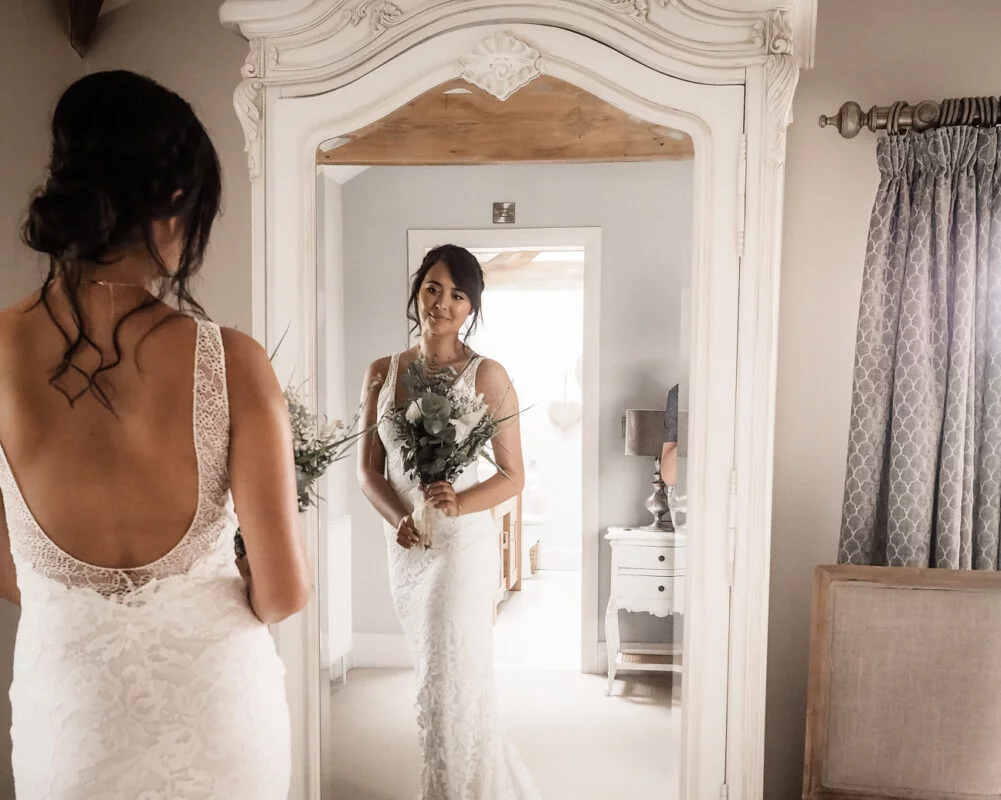A bride looking at herself in a mirror.