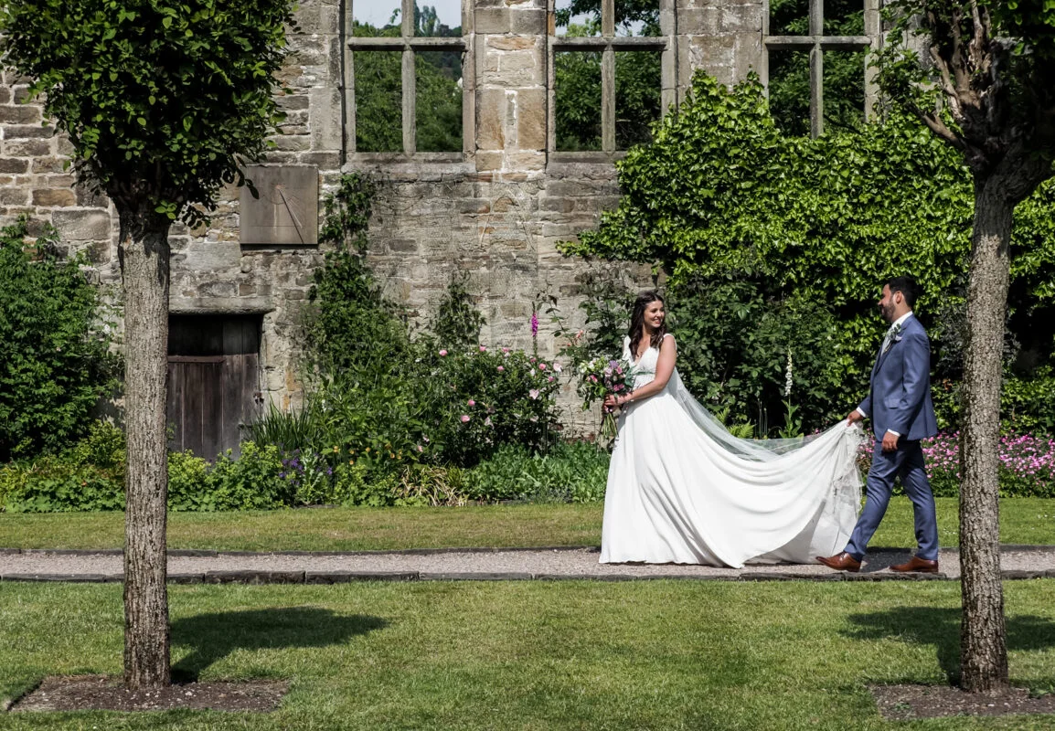 A bride and groom walking in front of a castle.