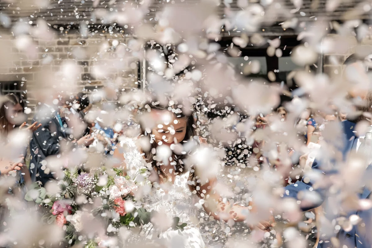 Confetti being thrown at a bride and groom.