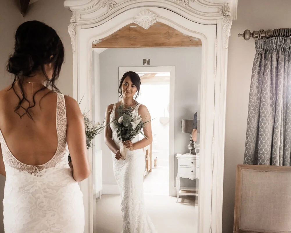 A bride looking at herself in a mirror.