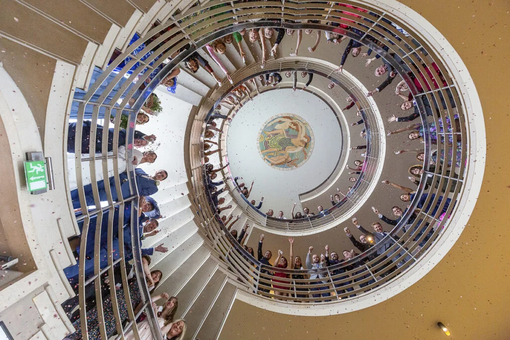 A group of people standing on a spiral staircase.