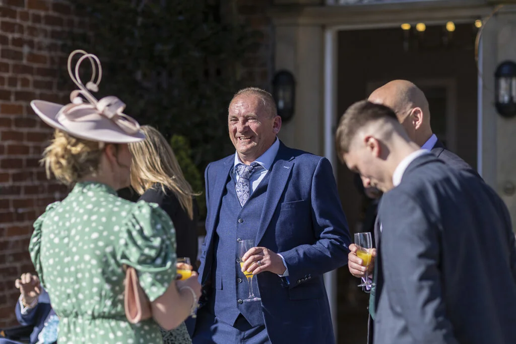 A man in a suit and tie is talking to a group of people.