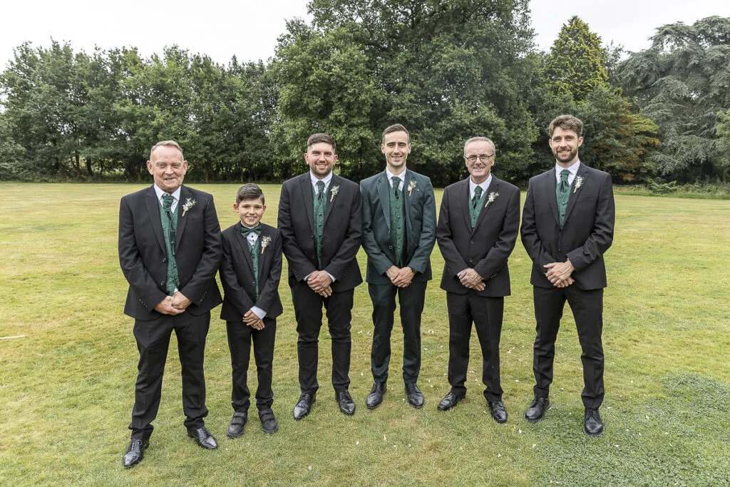 A group of groomsmen posing for a photo.