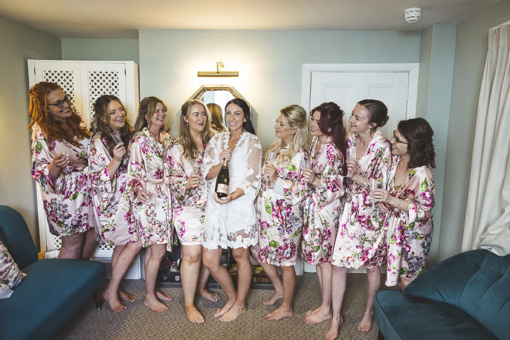 Bridesmaids in floral robes posing for a photo.