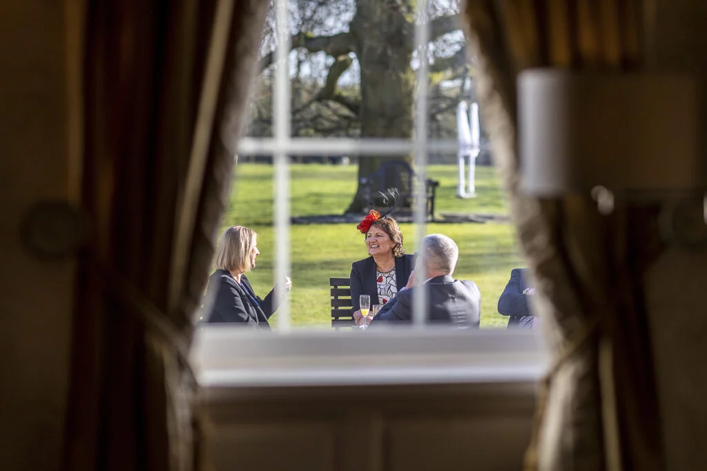 A group of people sitting in a room looking out of the window.