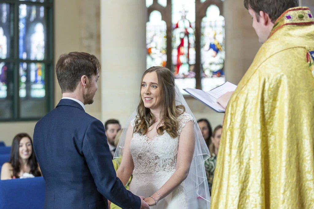 A bride and groom exchange vows in a church.