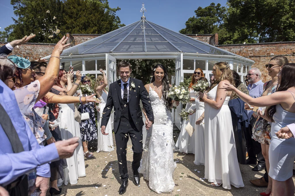 A bride and groom walk down the aisle at a wedding.