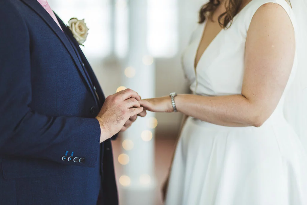 A bride and groom putting their wedding rings on.