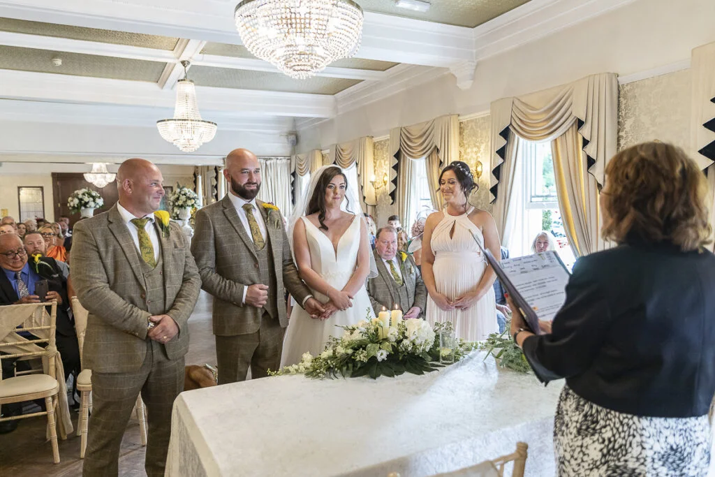 A wedding ceremony in a room with a bride and groom.