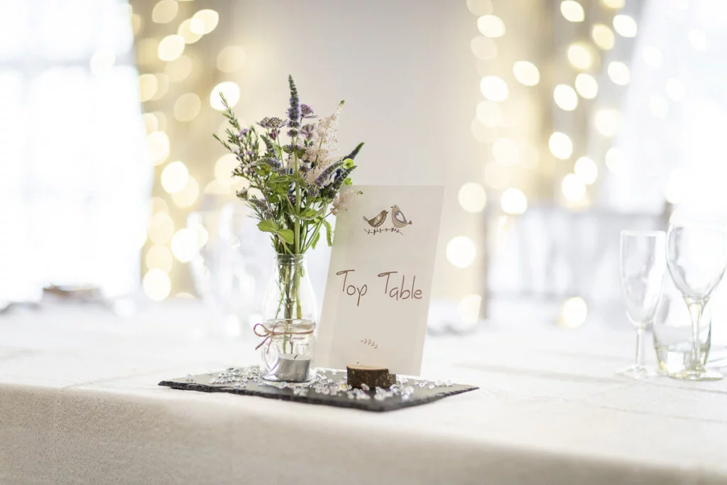 A table setting with flowers in a vase.