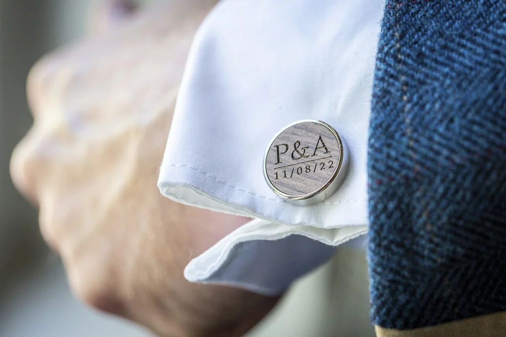 A man's cufflinks with a logo on them.