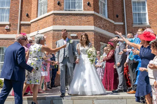 A bride and groom walking down the steps of a large building.