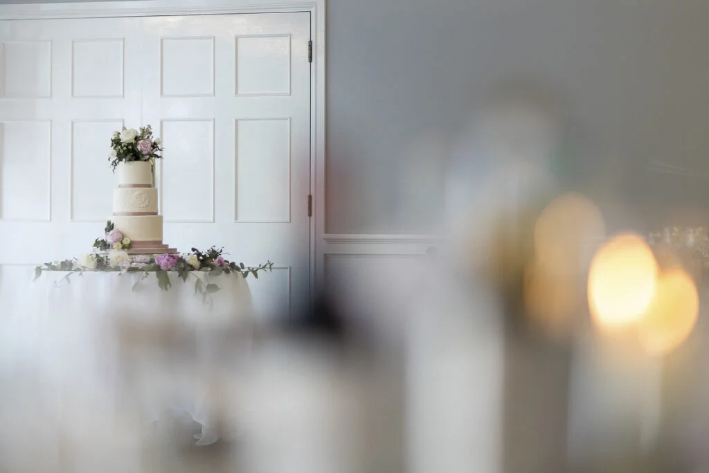 A wedding cake sits on a table in front of a door.