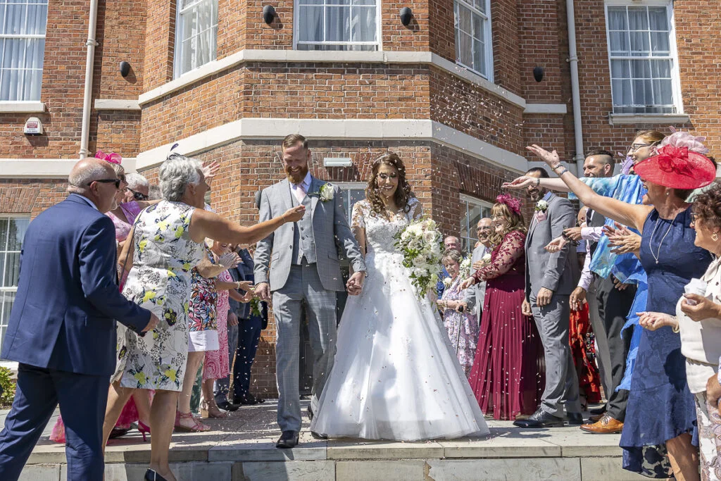 A bride and groom walking down the steps of a large building.