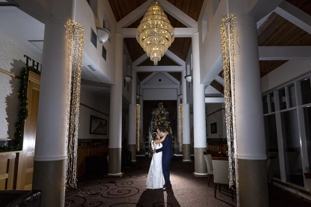 A bride and groom standing in the lobby of a hotel.