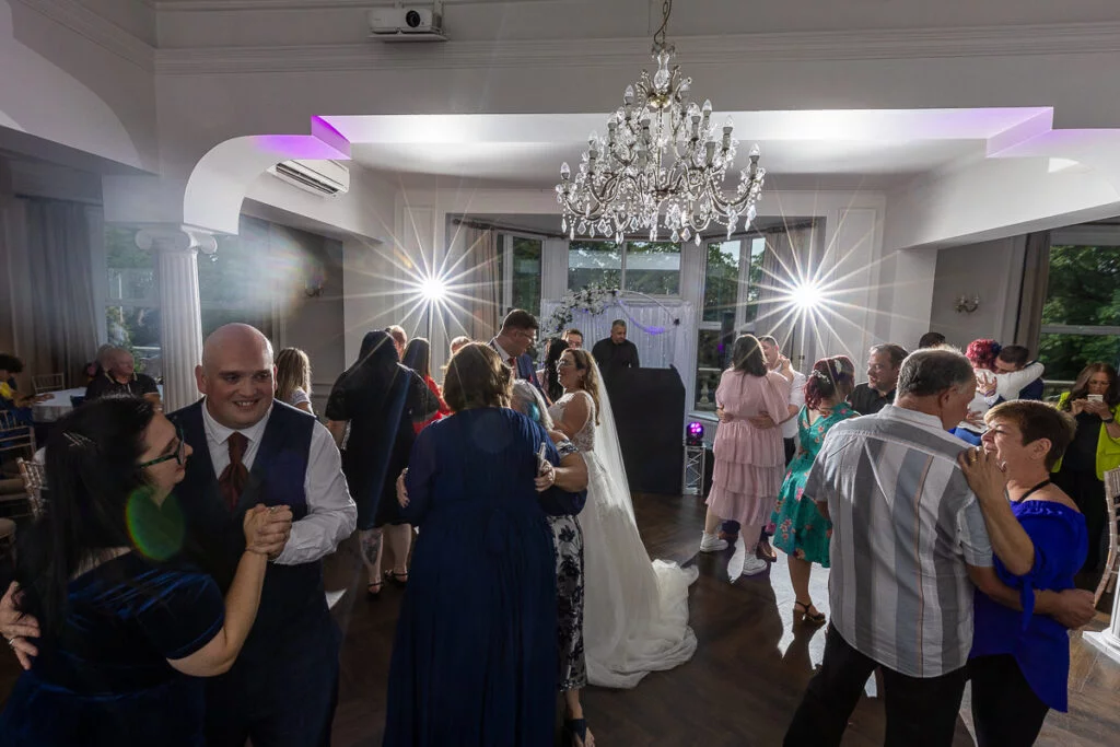 A group of people dancing at a wedding reception.