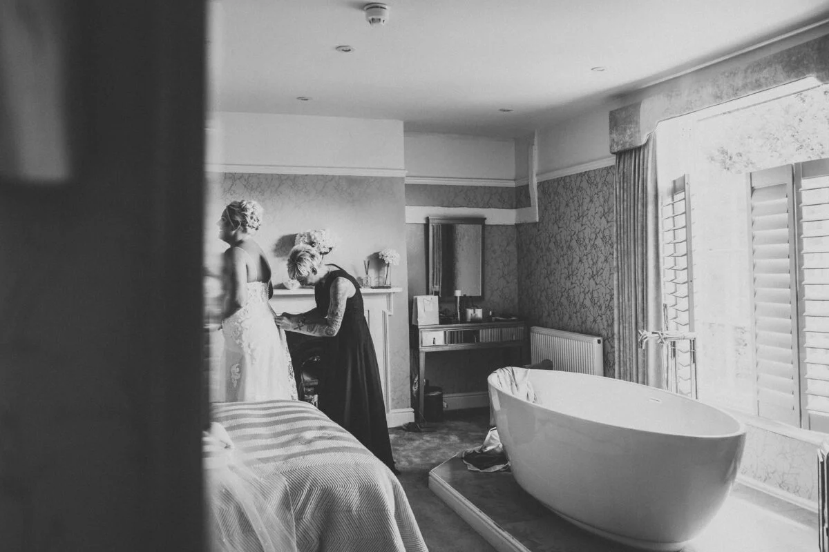 A bride getting ready in a room with a bathtub.
