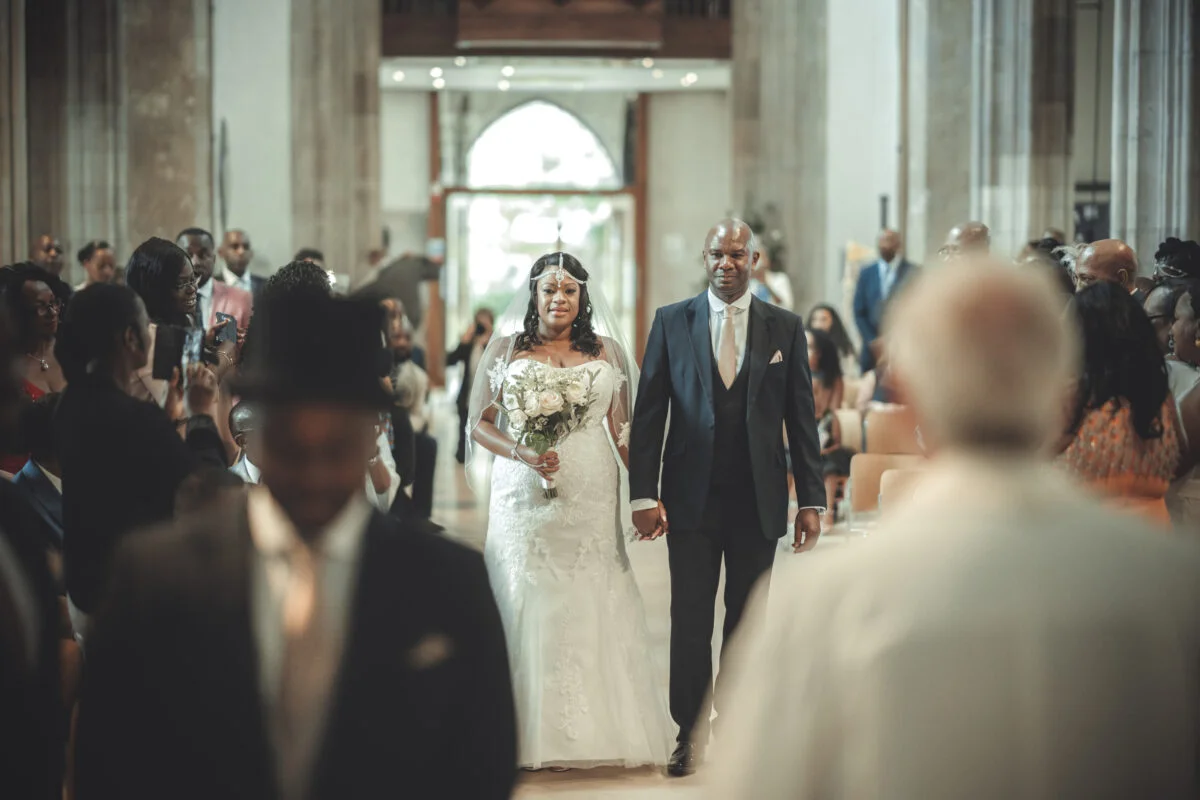 A bride and groom walking down the aisle of a church.