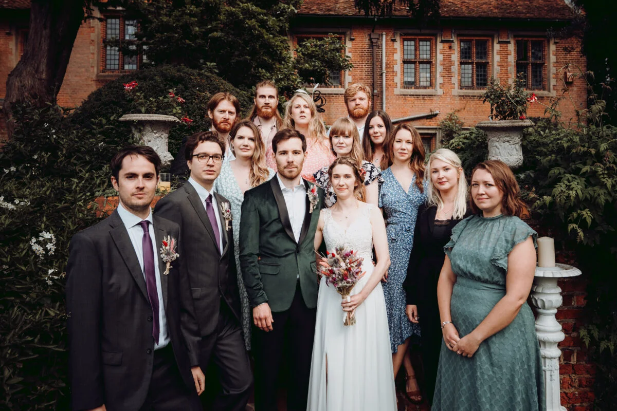 A wedding party posing in front of a house.