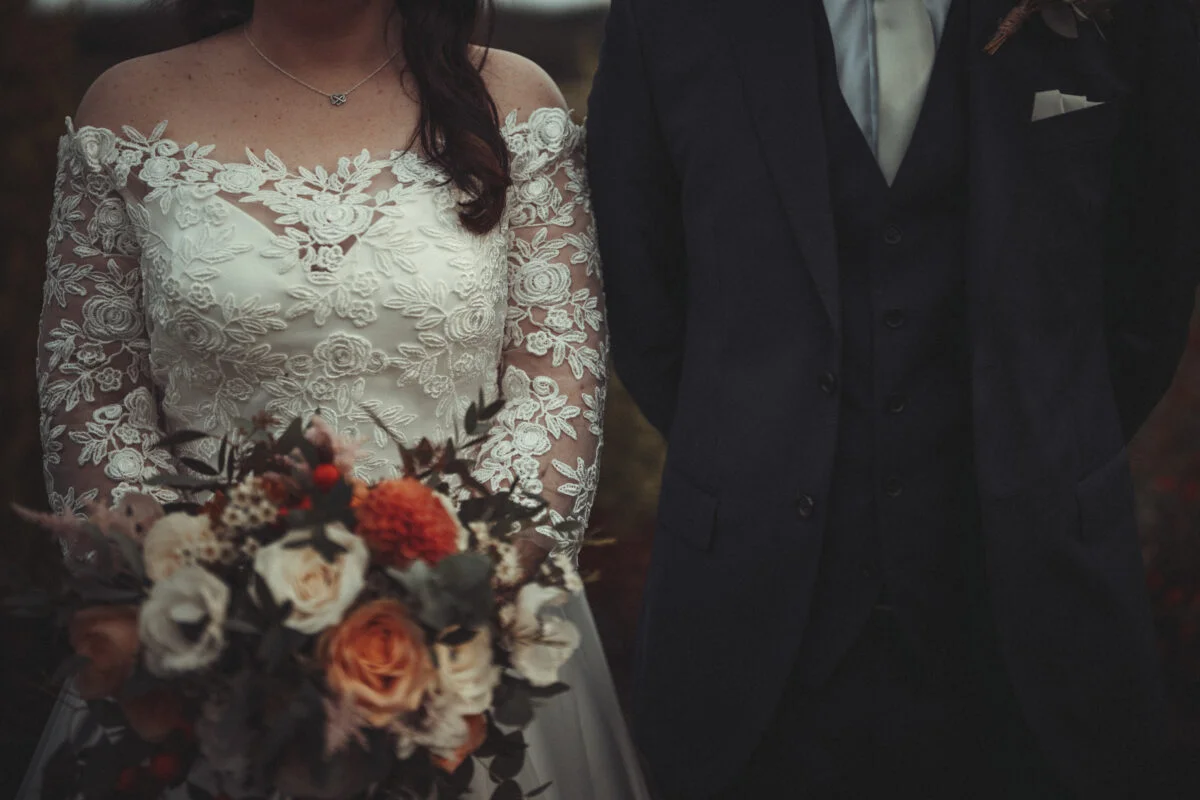 A bride and groom standing next to each other.