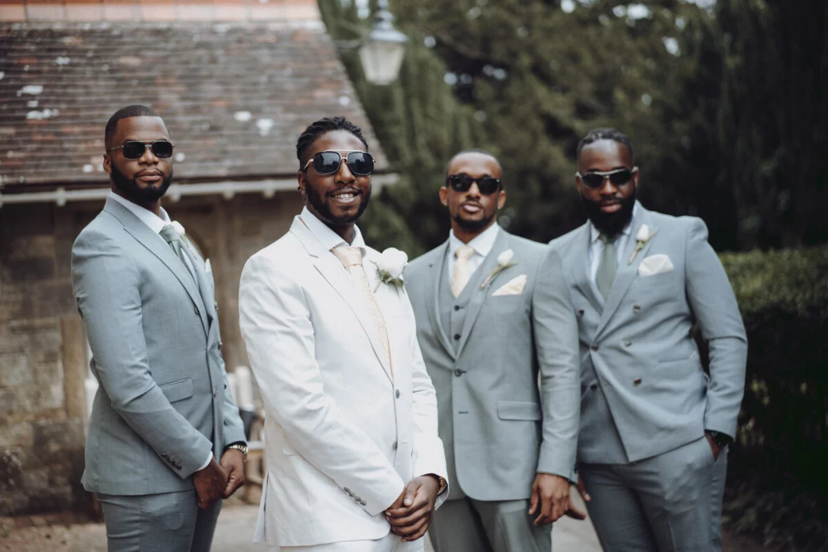 A group of groomsmen in suits posing for a photo.