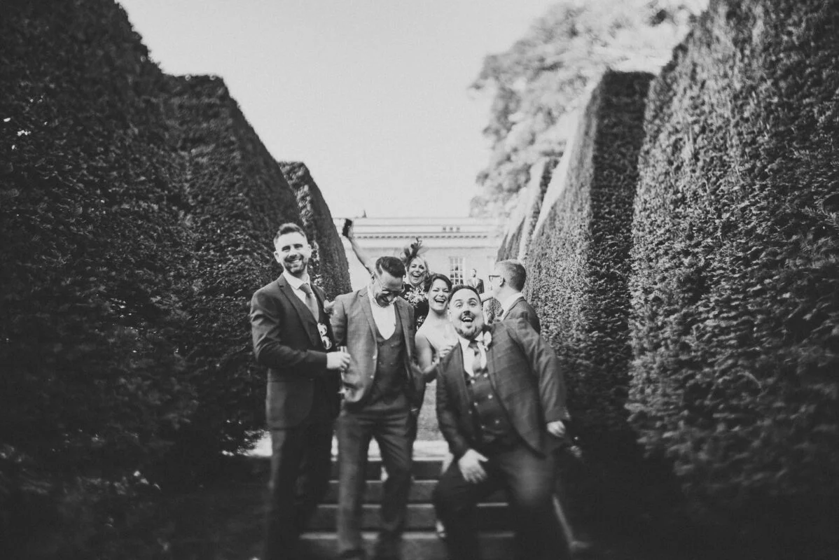 A black and white photo of a group of groomsmen and bridesmaids.