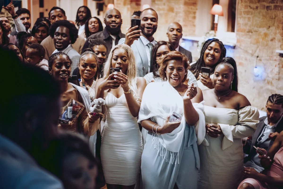A group of people posing for a photo at a wedding reception.