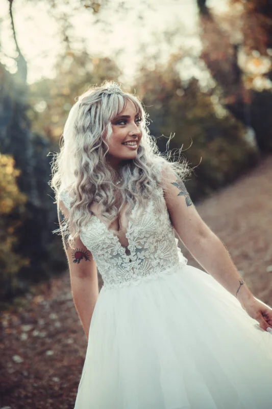 A bride in a wedding dress walking down a path.