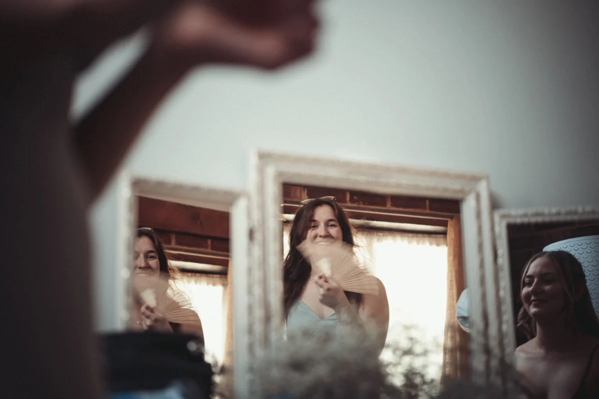 A woman is smiling in front of a mirror.
