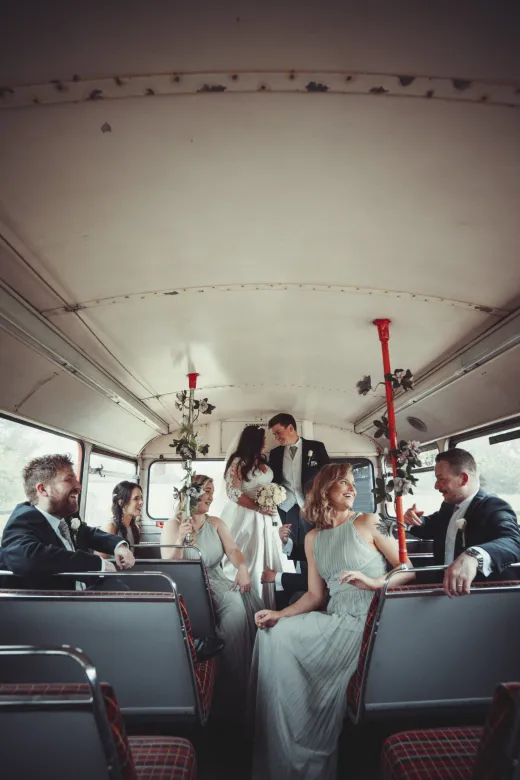 A group of bridesmaids and groomsmen on a bus. (listing)