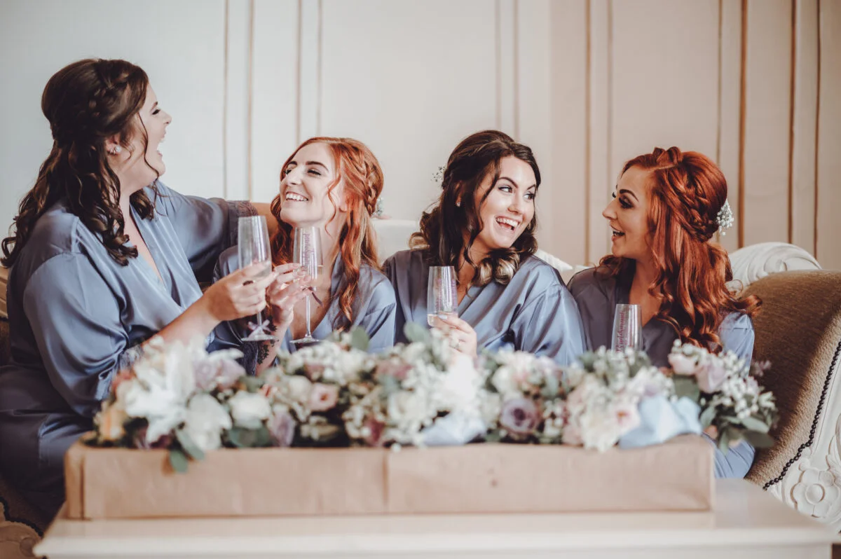 Four bridesmaids laughing on a couch.