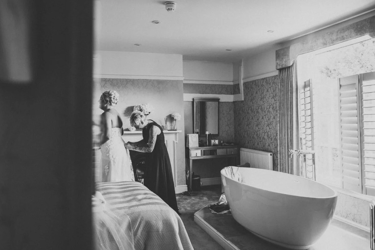 A bride getting ready in a room with a bathtub.