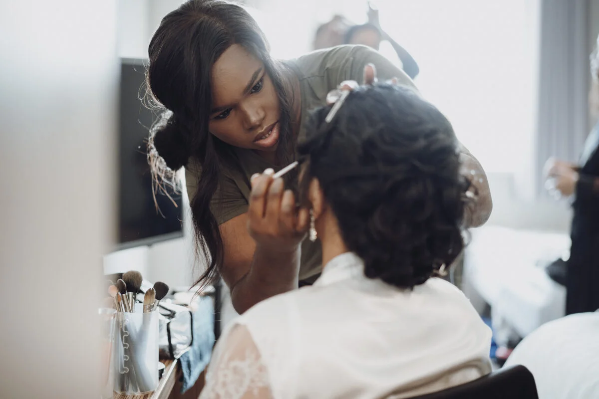 A woman getting her makeup done in a hotel room.