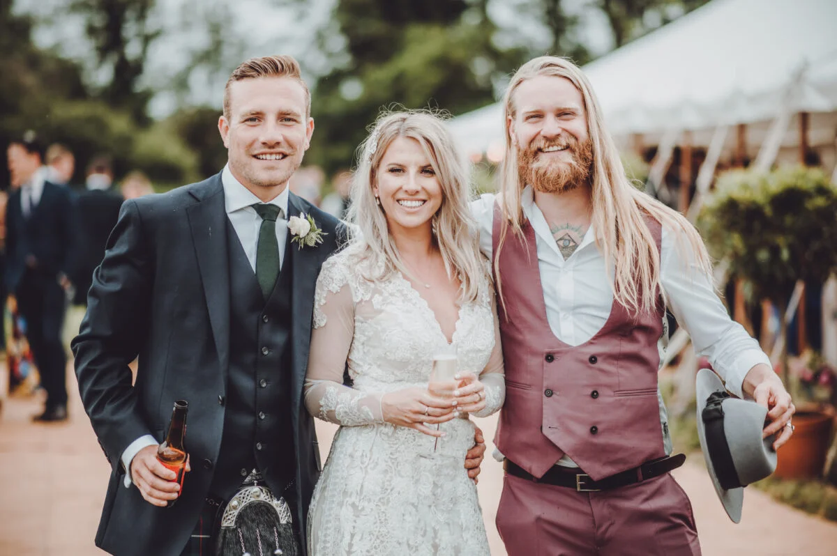 A bride and groom pose for a photo in a tent.