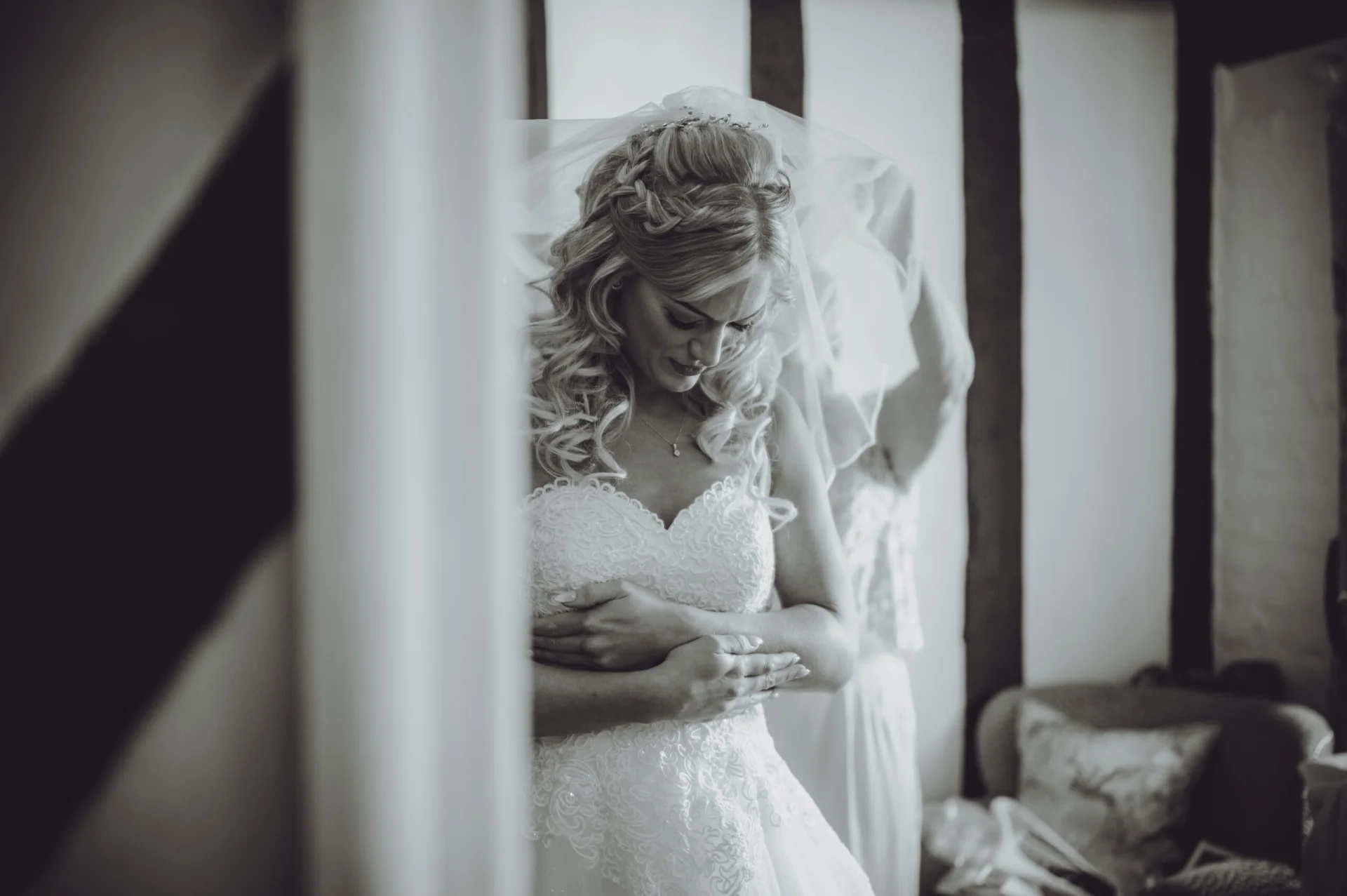 A bride is getting ready for her wedding in a black and white photo. (listing)