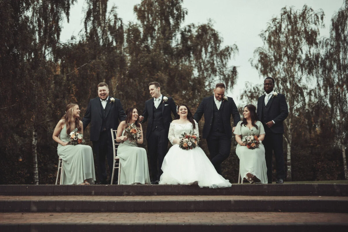 A group of bridesmaids and groomsmen posing for a photo.