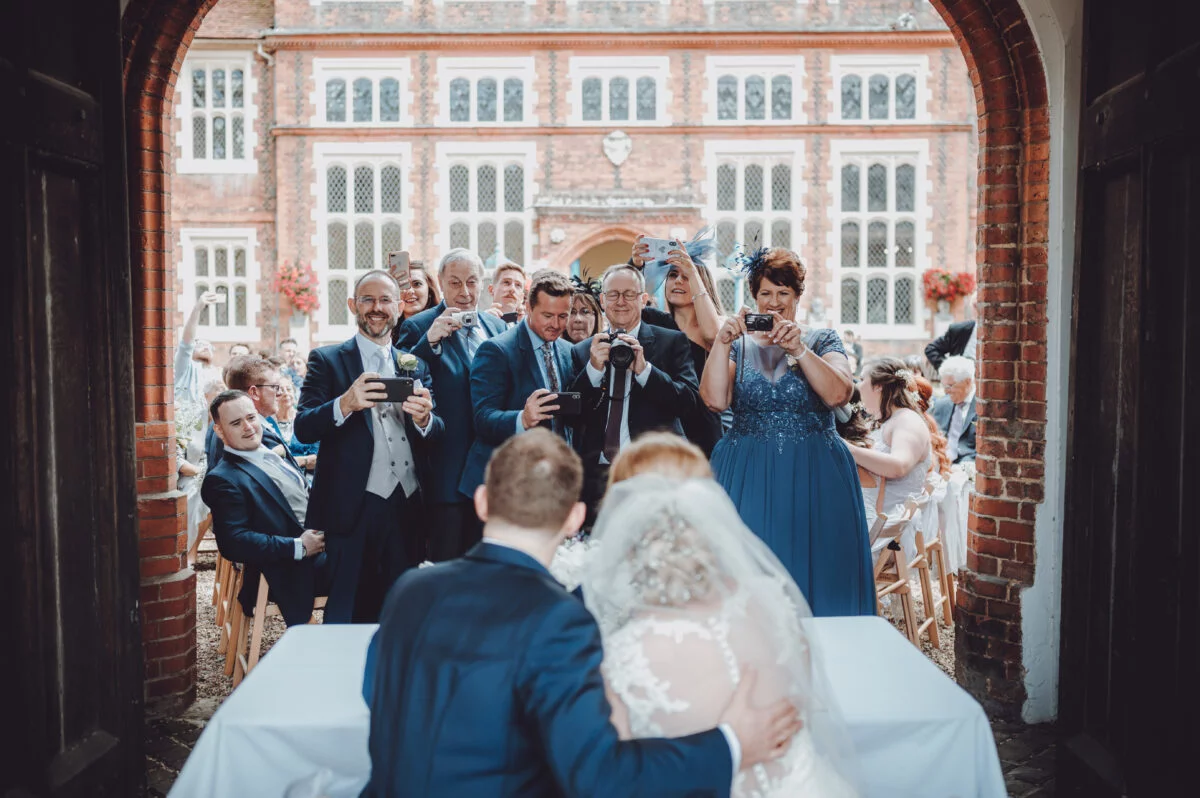 A bride and groom are getting married in front of their wedding party.
