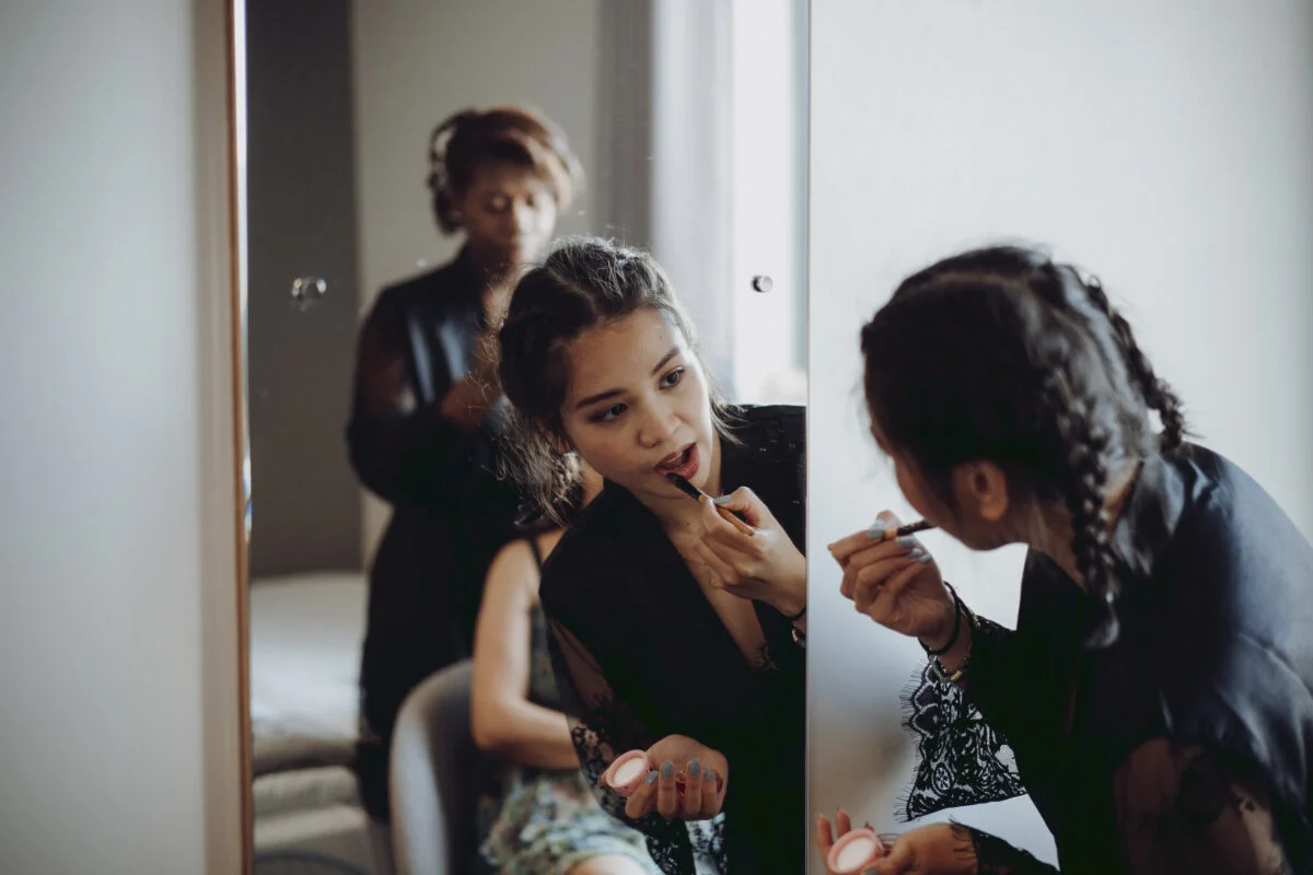 A bride getting ready in front of a mirror.