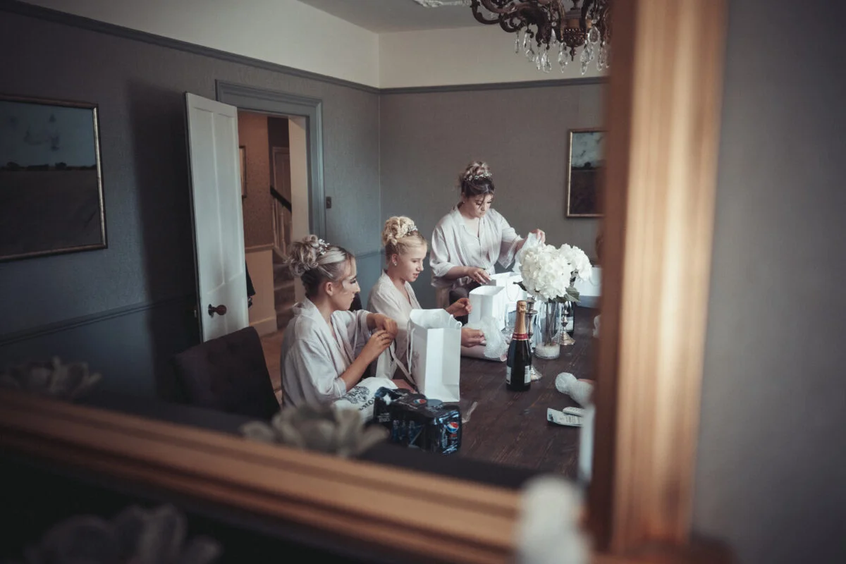 Bridesmaids getting ready in a mirror.